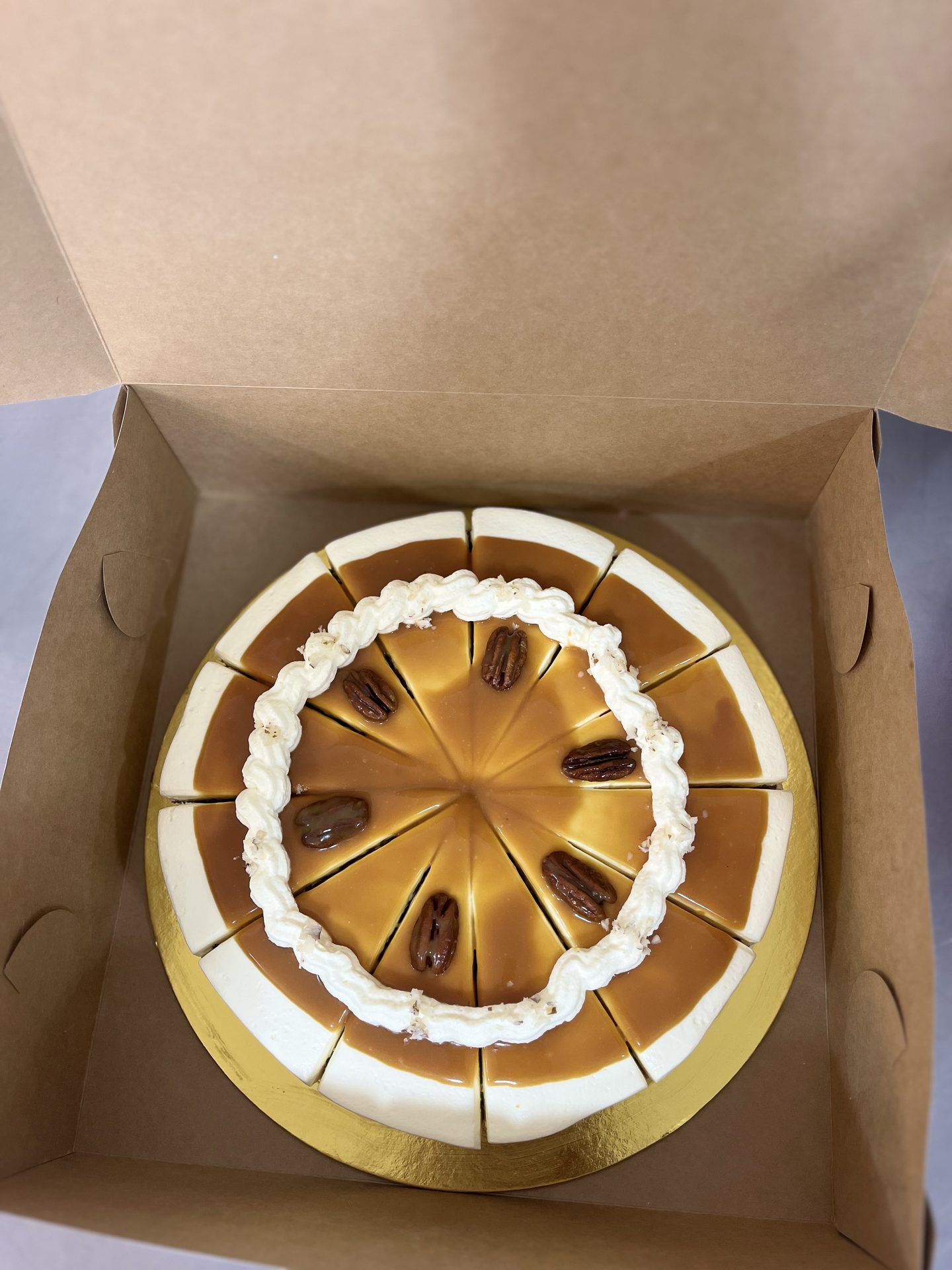 Torta de zanahoria entera, porcionada en 12, dentro de su caja